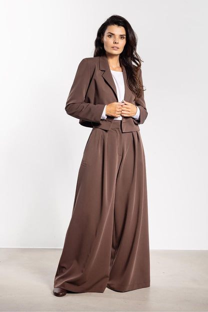 Model wearing Awama's elegant double-breasted jacket, styled with wide trousers for a modern and chic ensemble suitable for various occasions.