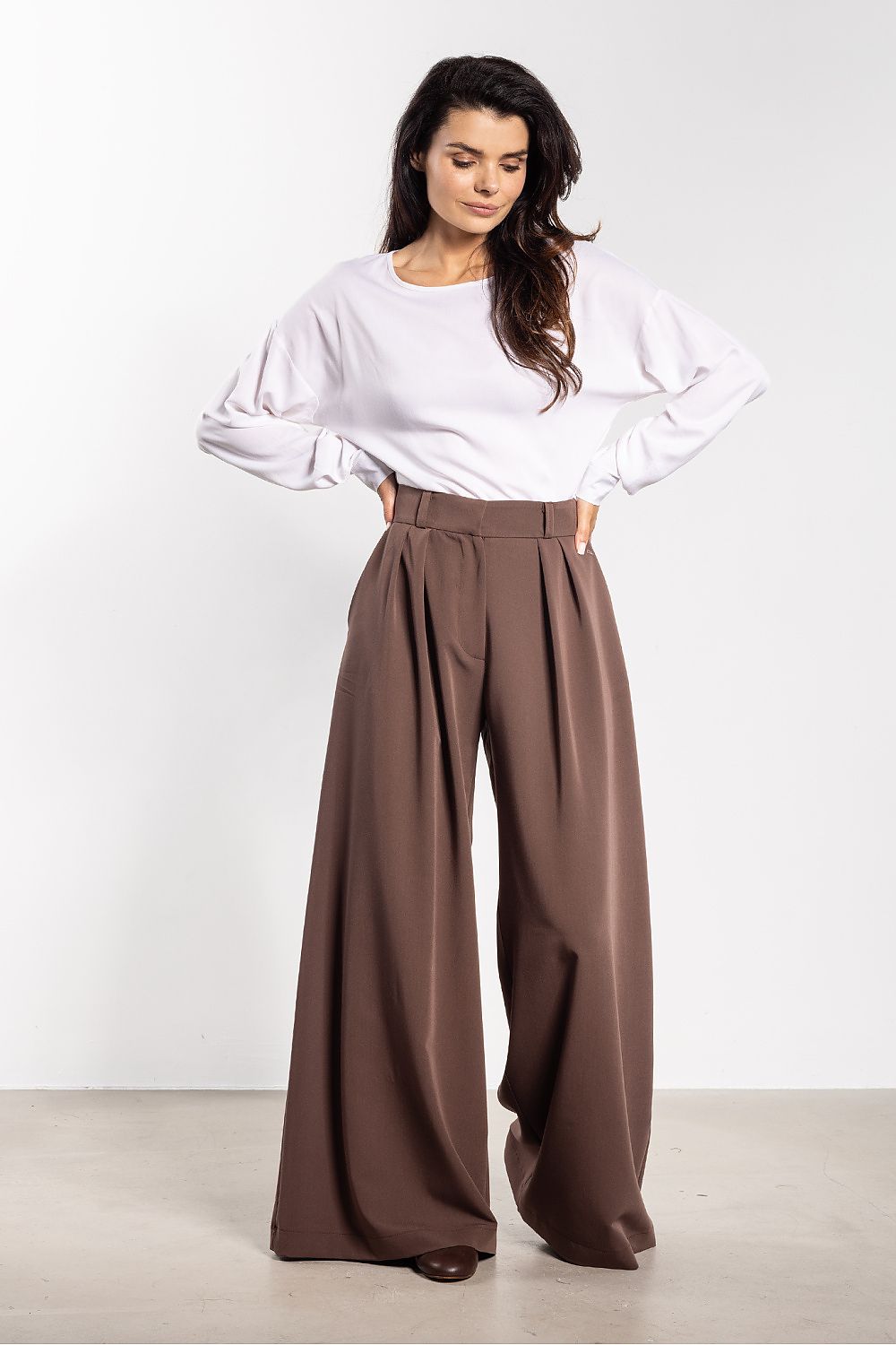 Elegant women's trousers by Awama displayed on a notice board, highlighting versatile styling options for various occasions with a timeless cut.