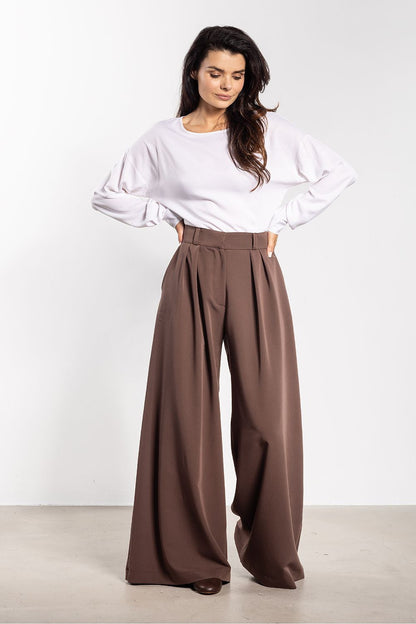 Elegant women's trousers by Awama displayed on a notice board, highlighting versatile styling options for various occasions with a timeless cut.