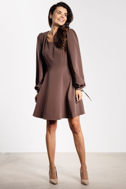 Model wearing the elegant Awama Fashion mini dress with long puffy sleeves, accentuating the neckline and shoulders.
