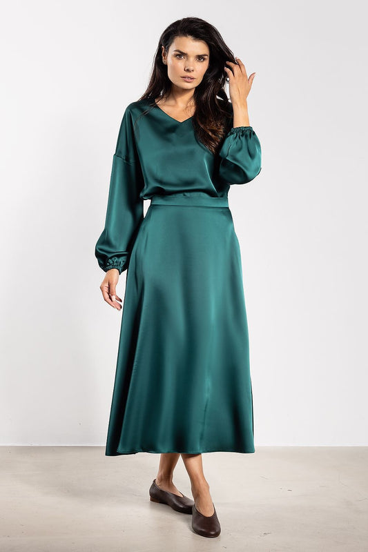 Close-up of the exquisite satin fabric of Awama's long-sleeve blouse, showcasing its delicate shine and elegant ruching at the cuffs.