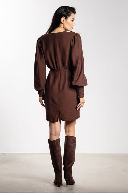 Stylish close-up of Awama's deep V-neck mini cocktail dress, showcasing the luxurious fabric and intricate ruching that flatters the silhouette.