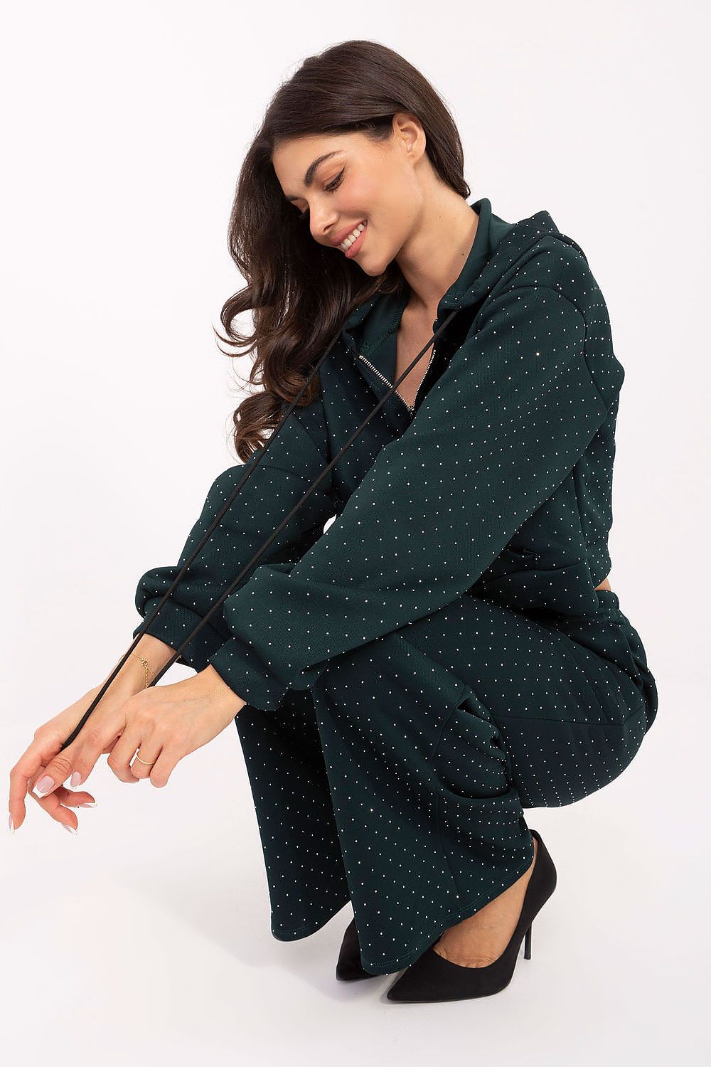 Model wearing Rue Paris elegant women's tracksuit set, emphasizing the stylish high-waisted trousers and long-sleeved zip-up hoodie with practical design elements.