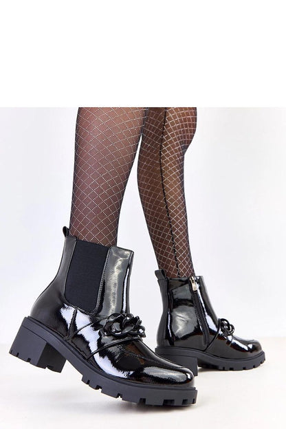 Luxurious black ankle boots designed by Solea, featuring a unique decorative chain and a 5.5 cm stable heel, combining fashion and comfort effortlessly.