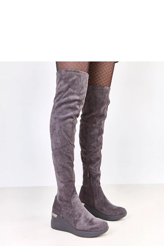 Solea stylish knee-high buskin boots in eco-suede featuring a chic wedge heel, elegantly highlighting legs for a sophisticated look.