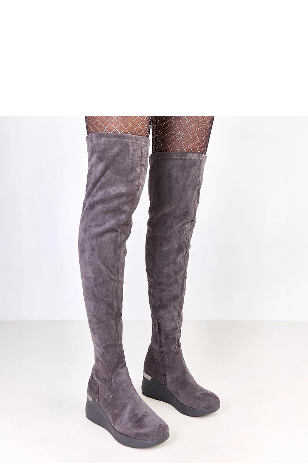 Close-up view of Solea eco-suede knee-high boots featuring a rounded slender toe and metallic heel insert, perfect for chic winter fashion.
