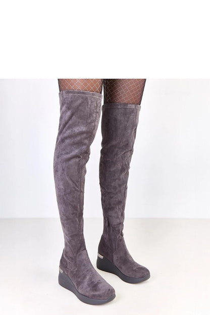 Close-up view of Solea eco-suede knee-high boots featuring a rounded slender toe and metallic heel insert, perfect for chic winter fashion.