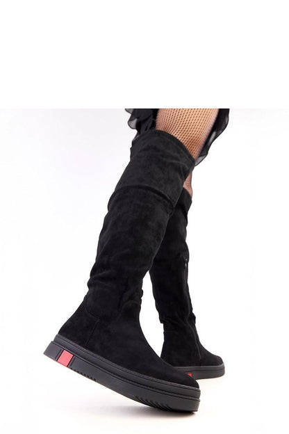 Solea thigh-high platform boots displayed with a charming background, exemplifying comfort and modern fashion ideal for chic everyday styling.