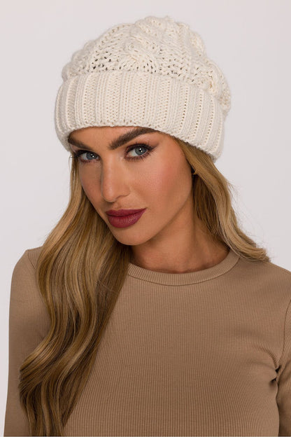 Model wearing the luxury braided knit cap by Moe in a cozy outdoor setting, demonstrating its warmth and elegant knit design ideal for winter fashion.