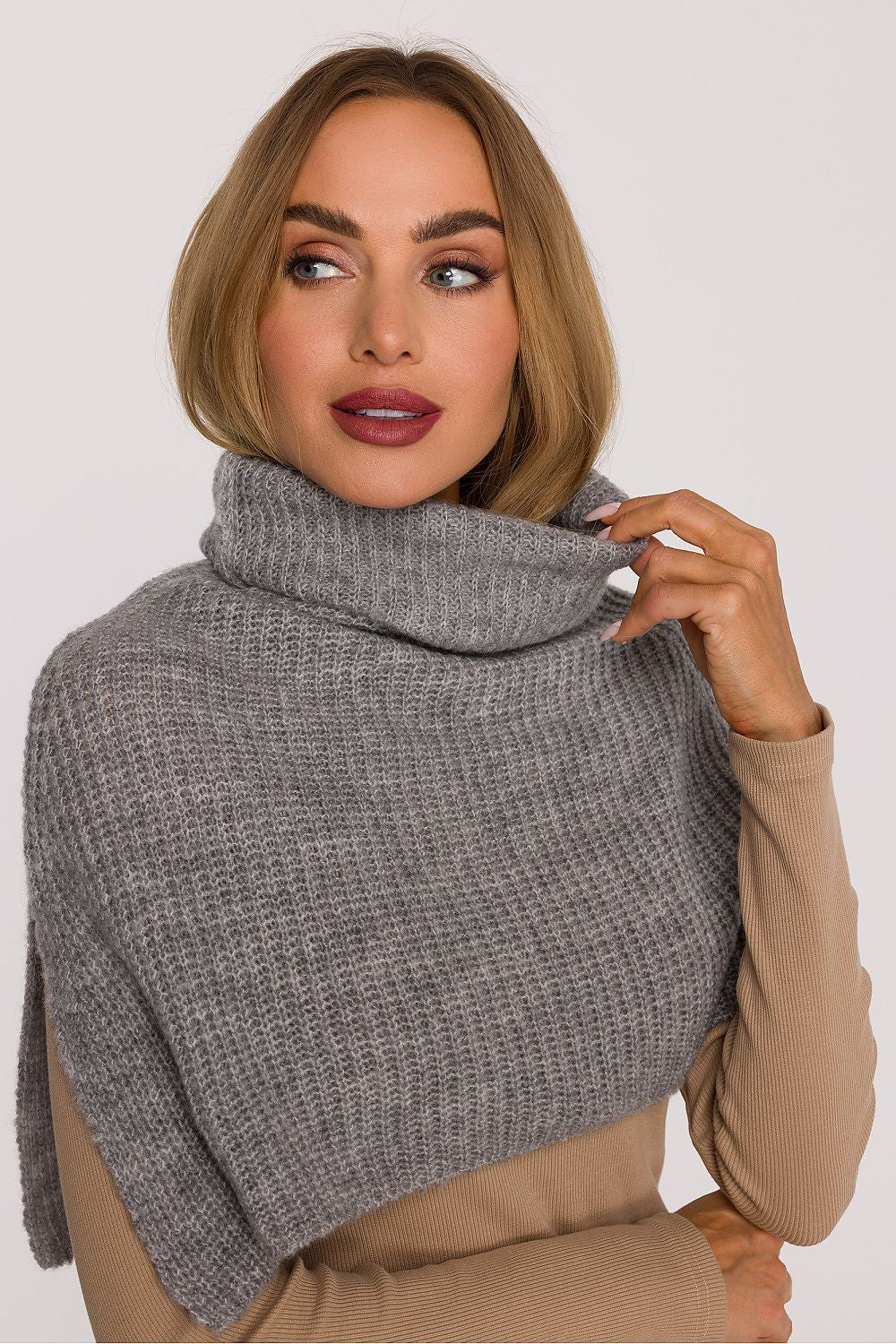 Moe's luxurious infinity scarf showcasing a loose weave, designed to envelop the neck and arms in exceptional warmth.