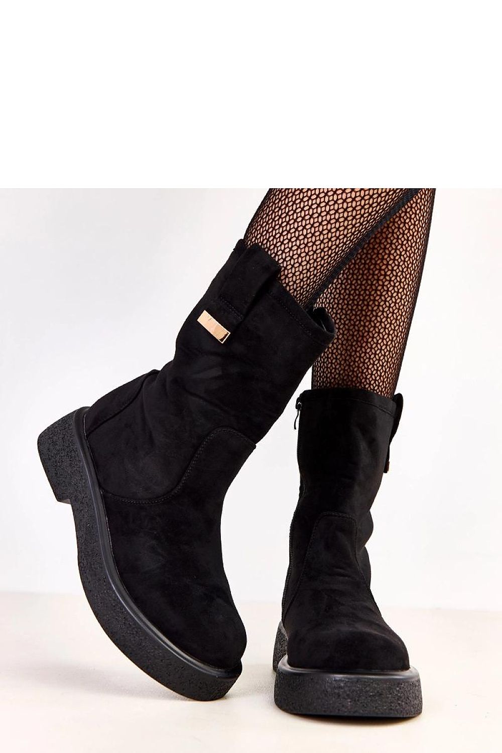 A pair of Solea women's ankle boots in a fashionable setting, featuring a 19cm shaft height and delicate metal decoration for an upscale appeal.