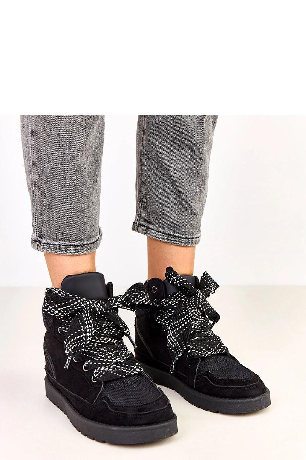 Close-up of Solea suede-like sports shoes, highlighting the distinctive thick laces and 2.5cm platform, combining elegance and sporty aesthetics.