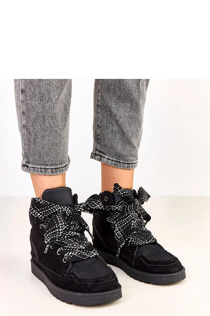 Close-up of Solea suede-like sports shoes, highlighting the distinctive thick laces and 2.5cm platform, combining elegance and sporty aesthetics.