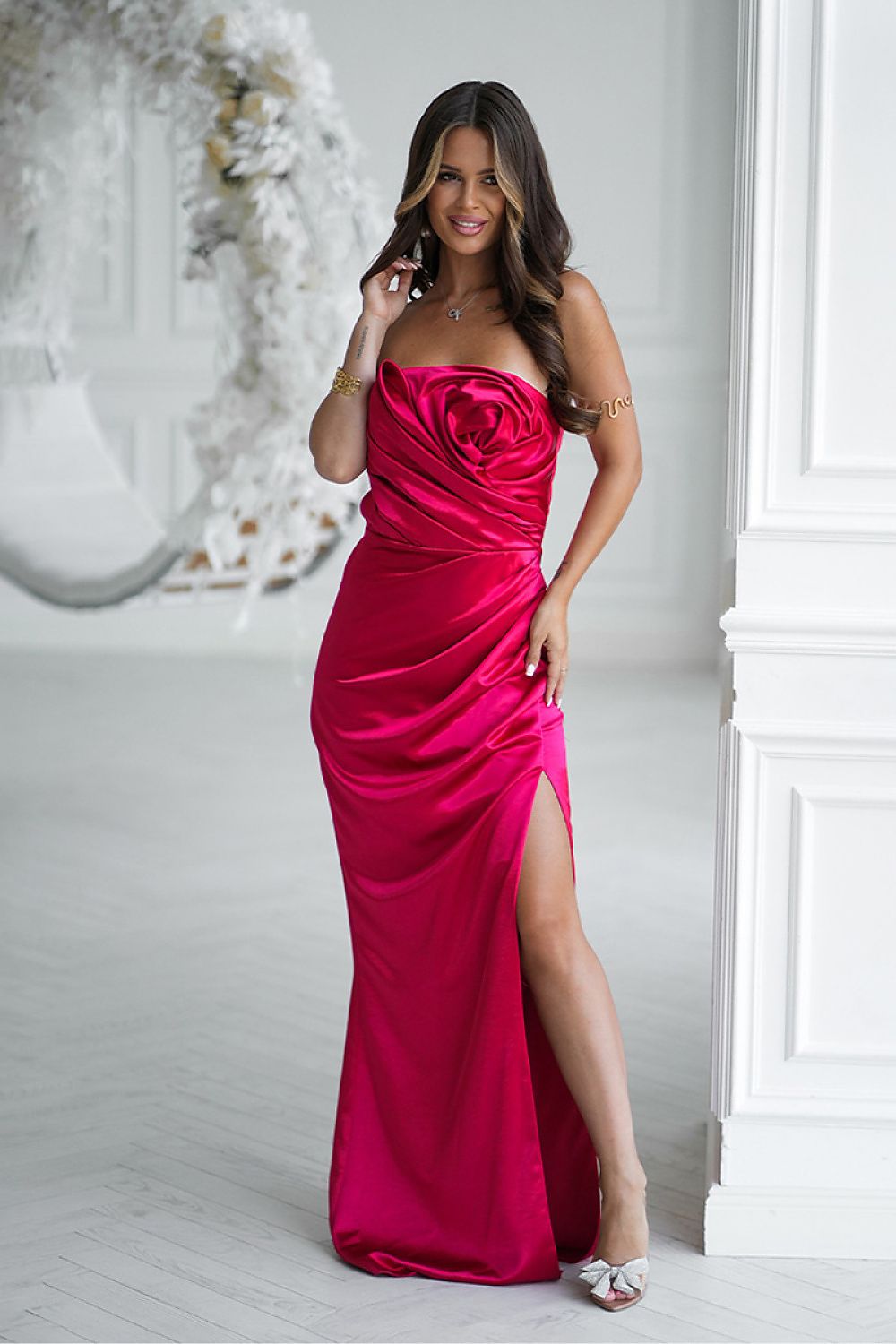 Elegant strapless satin long dress by Bicotone, adorned with a large draped rose on the bust and featuring a high slit, perfect for special occasions and evening outings.