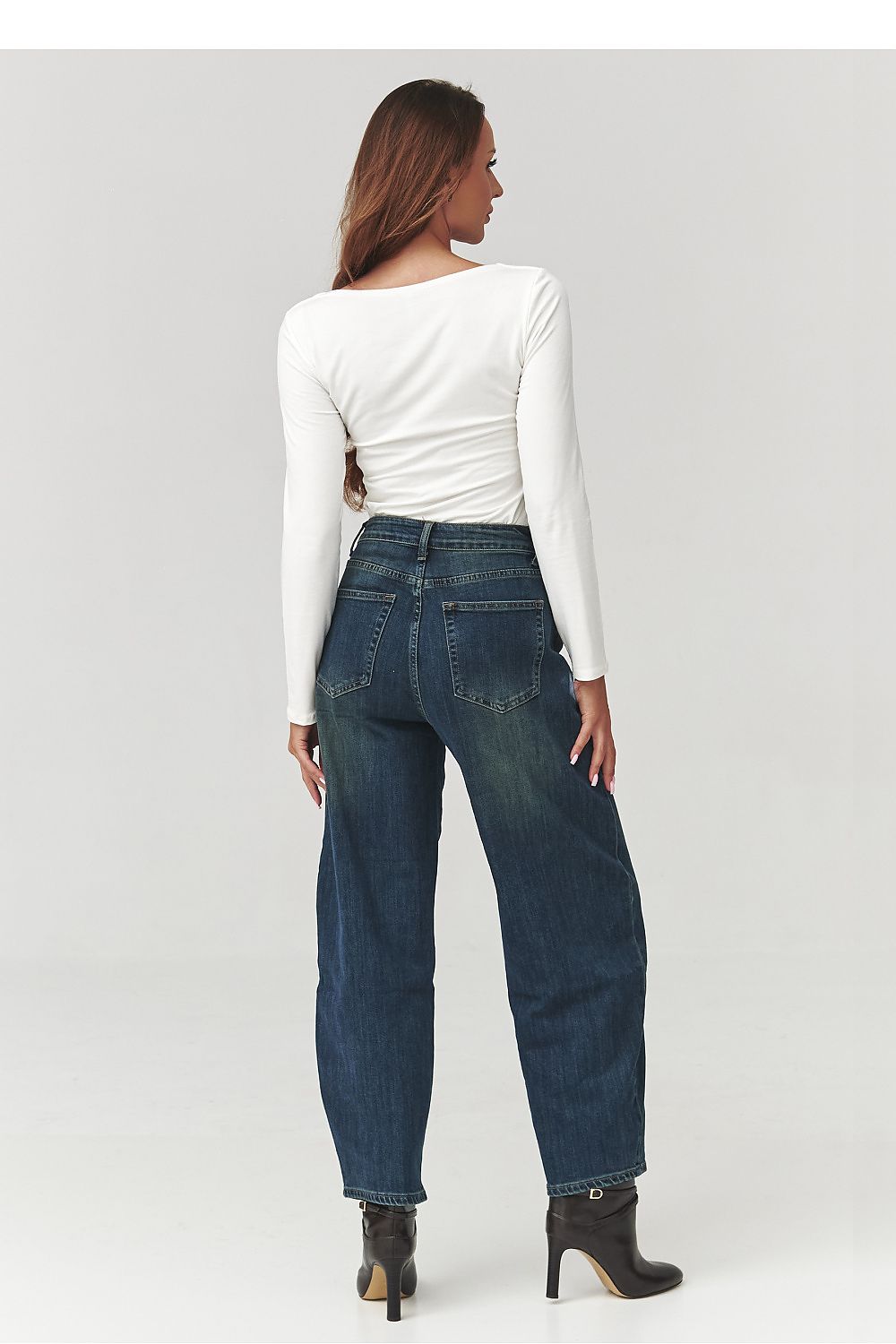 Model wearing the Makadamia blouse with checkered neckline styled with elegant trousers, ideal for casual or formal occasions.