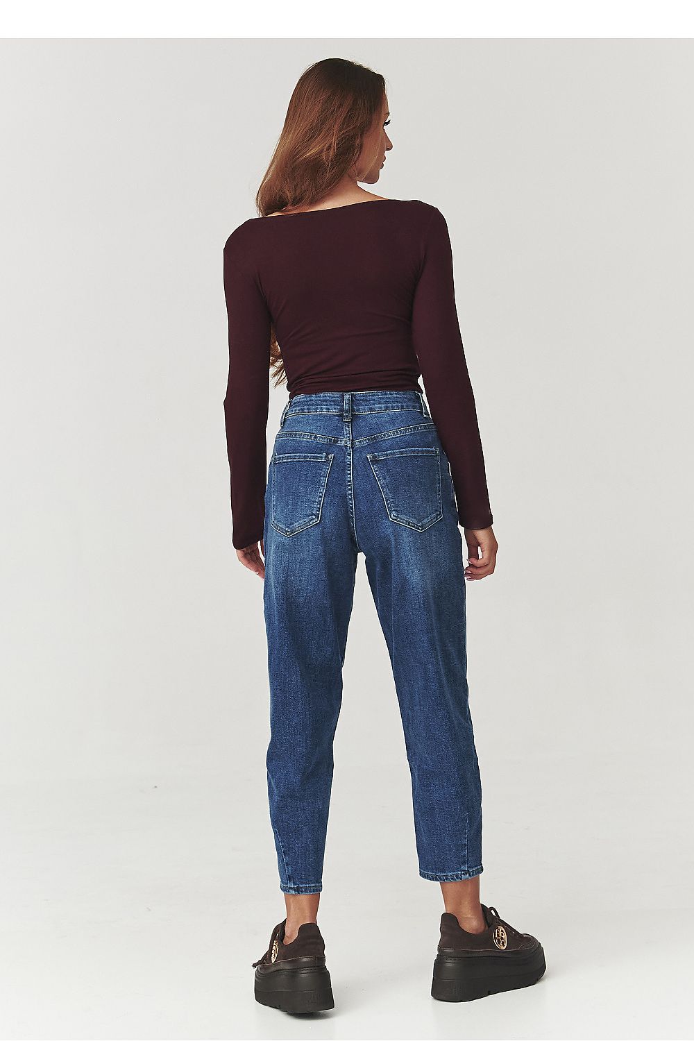 Full view of the Makadamia blouse styled with jeans, demonstrating its versatility for casual and high-end outfits with a chic look.