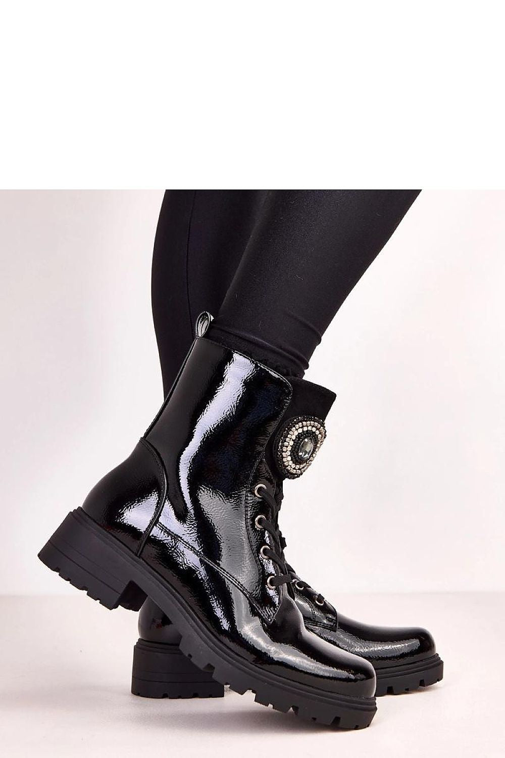 Chic Solea ankle boots with a modern round toe and detailed ornamental tongue, offering luxurious style and thermal comfort.