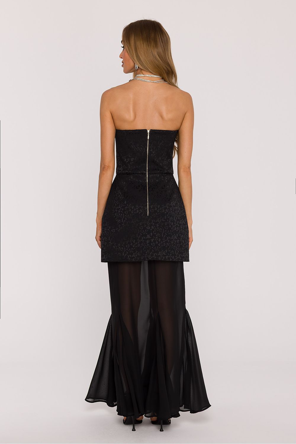 Back view of Moe's elegant evening dress, highlighting the covered zipper closure and the fitted waist for a sophisticated silhouette.