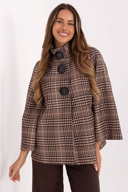 Luxurious checkered women's coat by Italy Moda, crafted from high-quality polyester blend. This elegant standard length coat features a stylish design with a stand-up collar and large button fastening, perfect for both casual and refined outfits.