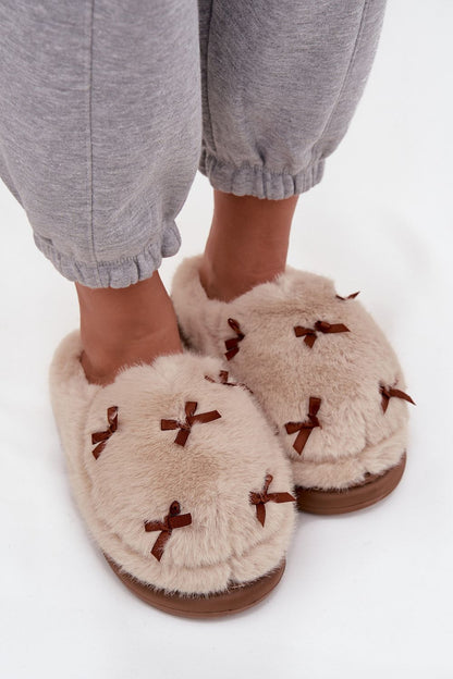 Luxurious women's fur slippers featuring decorative bows, ideal for a warm and fashionable indoor experience from Step in Style.