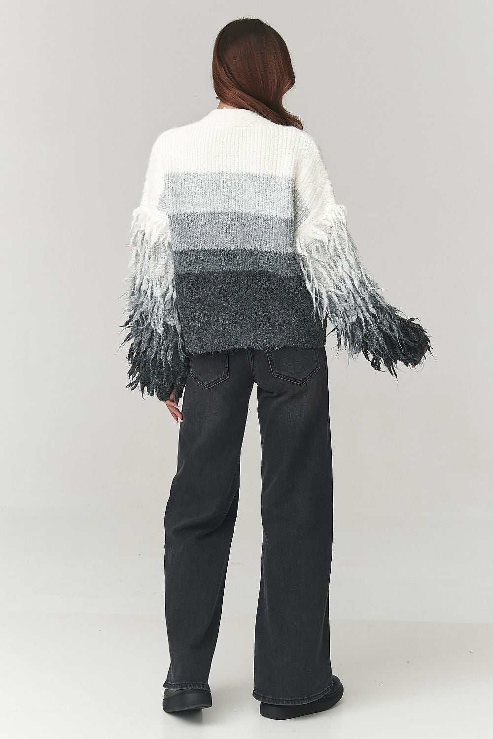 Fashion-forward woman wearing the Makadamia luxury ombre cardigan, effortlessly styled with jeans for a chic, modern look.