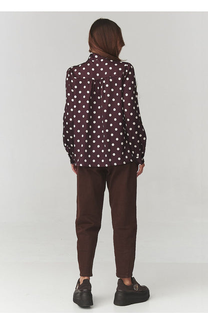 Close-up view of Makadamia's stylish polka dot shirt, showcasing the soft fabric texture and tailored silhouette designed for comfort and elegance.