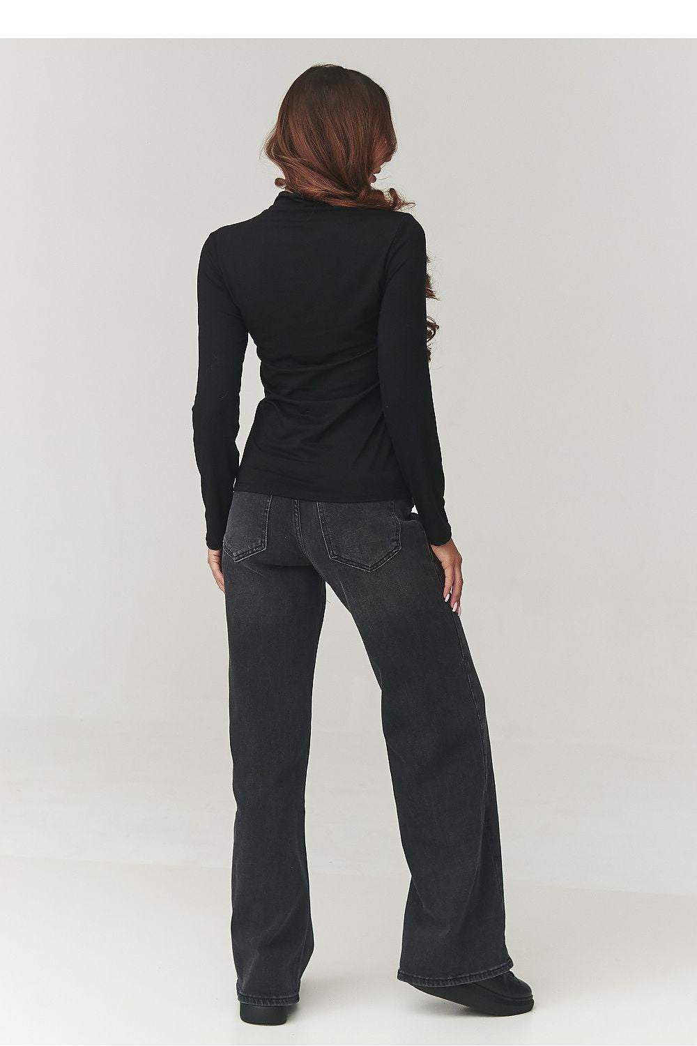 Model wearing Makadamia's elegant women's turtleneck blouse in subtle cappuccino, demonstrating its versatility for various occasions.