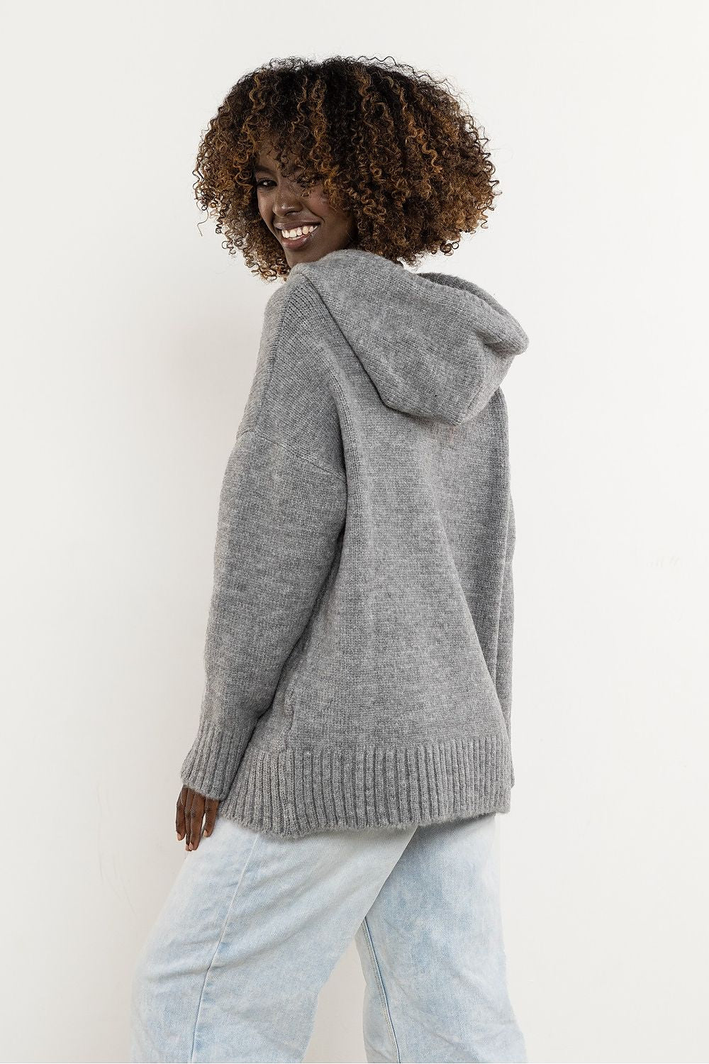 Stylish model wearing the Awama elegant wool hooded sweater, exemplifying timeless elegance and versatility in a chic outfit.