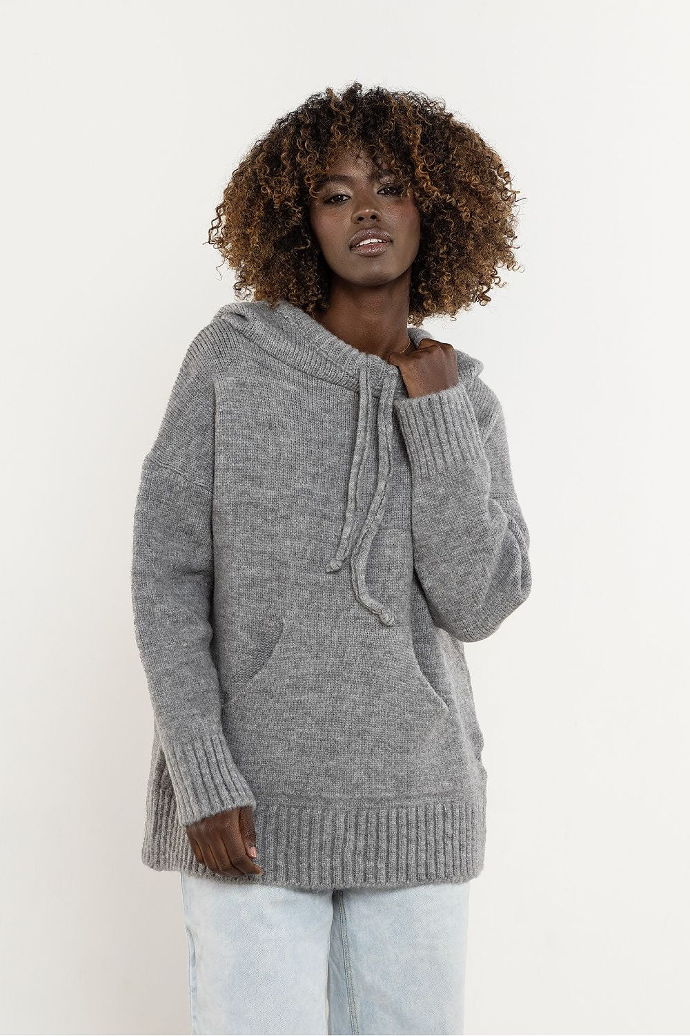 Detail of the elegant minimalistic design and hood feature of the Awama wool sweater, ideal for sophisticated winter looks.
