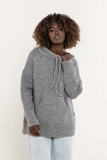Detail of the elegant minimalistic design and hood feature of the Awama wool sweater, ideal for sophisticated winter looks.