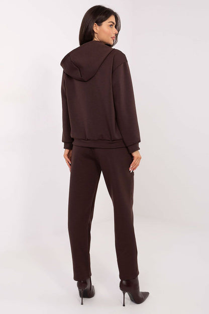Close-up of Italy Moda women's tracksuit set showcasing the elegant decorative brooches on chest pockets and the comfortable, tapered pant legs.