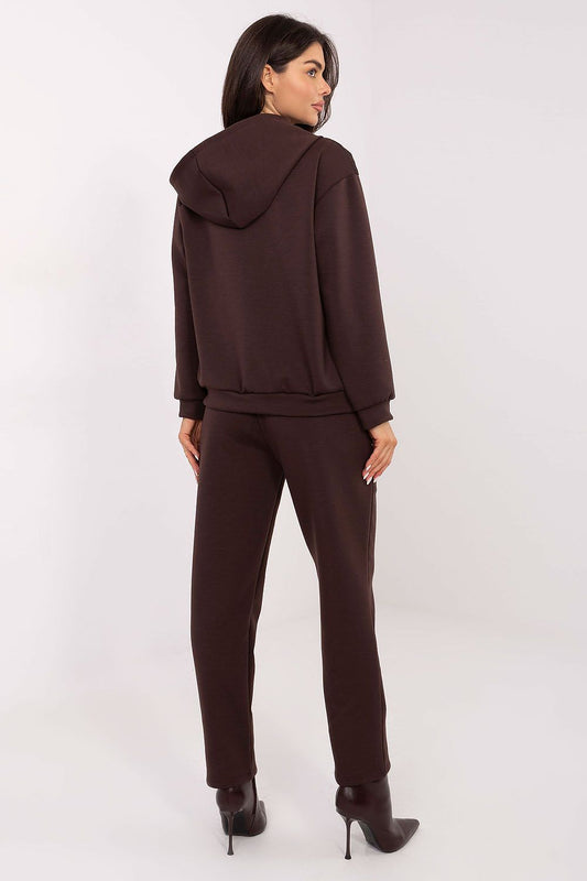 Close-up of Italy Moda women's tracksuit set showcasing the elegant decorative brooches on chest pockets and the comfortable, tapered pant legs.