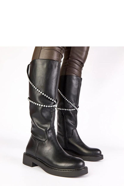 Close-up of Solea's black thigh-high boots featuring a stylish zircon strap, showcasing the exquisite craftsmanship and comfort.