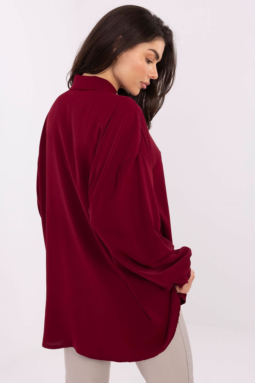 Model wearing an elegant long-line polyester blouse with puff sleeves by Factory Price, exuding confidence and sophistication in a chic setting.