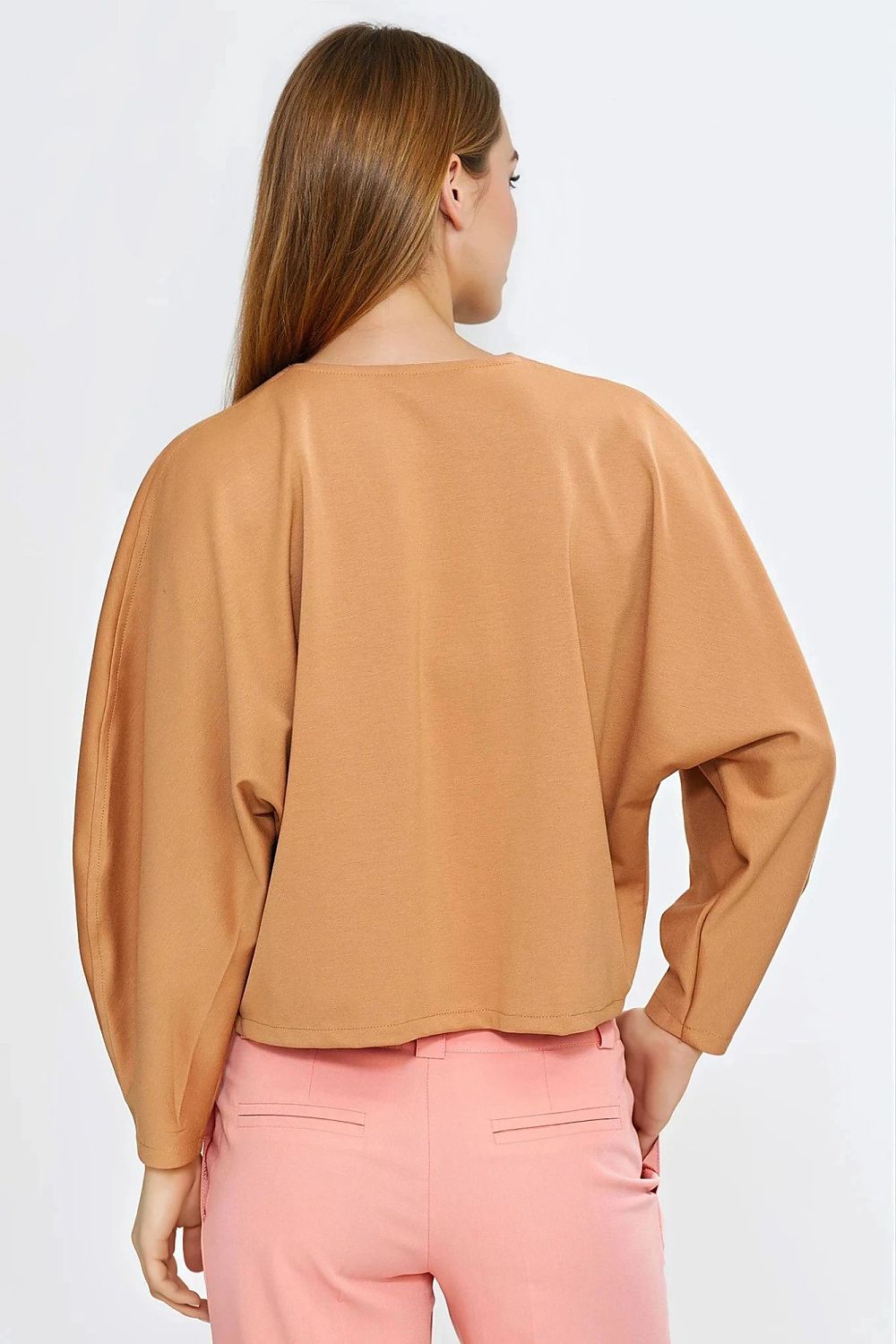 Nife oversized v-neck blouse styled with high-waisted trousers, illustrating its versatility as a must-have piece for both casual and formal occasions.