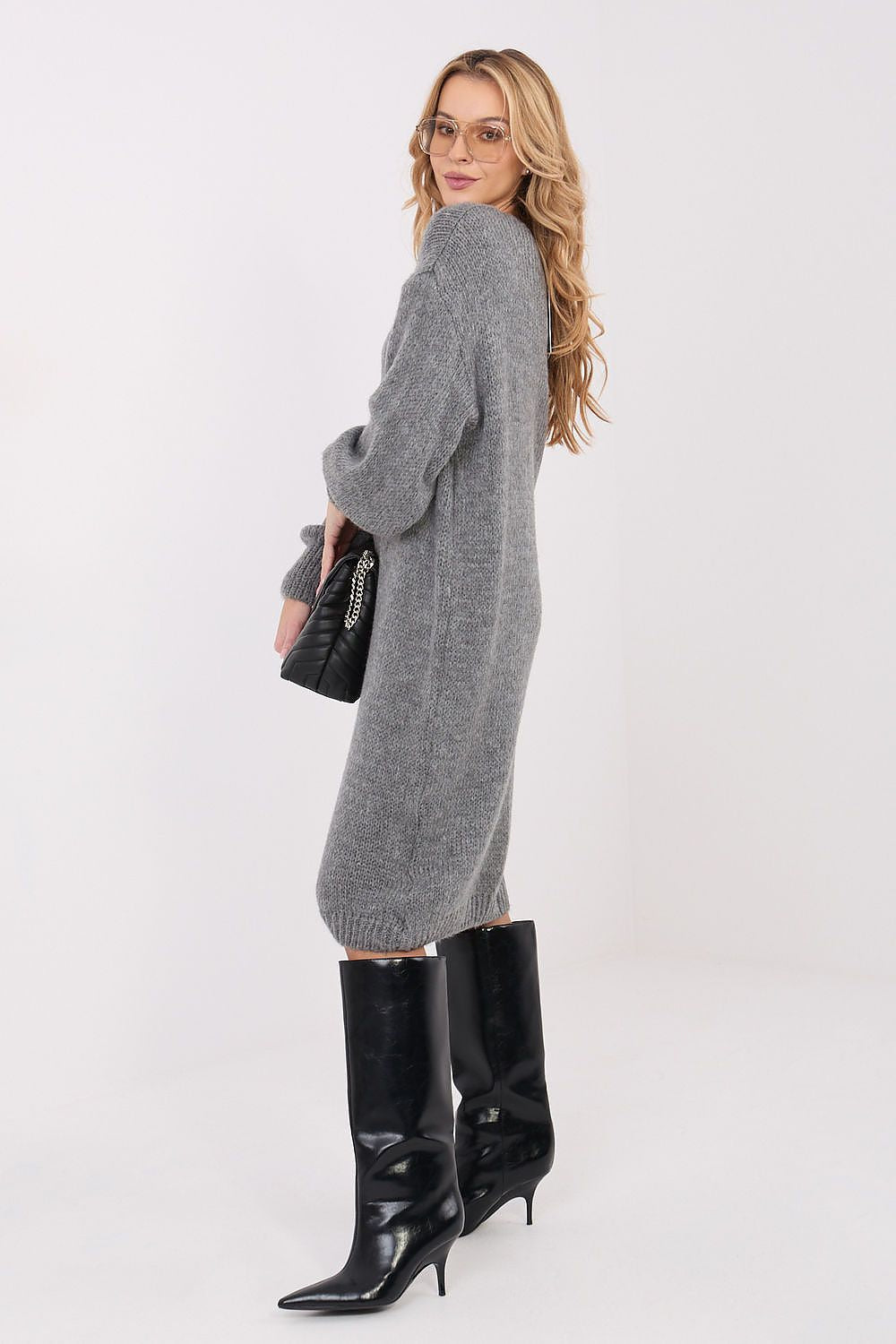 Model wearing Factory Price's elegant oversized knit midi sweater dress with v-neck, capturing the beauty of casual luxury and timeless style.
