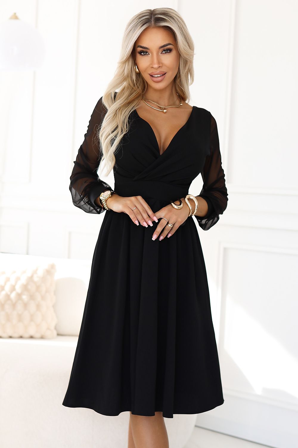 Elegant black midi dress with tulle sleeves by Numoco, showcasing timeless style and a perfect fit, ideal for formal occasions and celebrations.