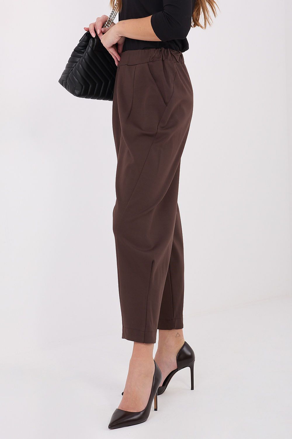 Side view of Rue Paris high-waisted trousers showcasing tapered legs and elastic waistband for a flattering silhouette.