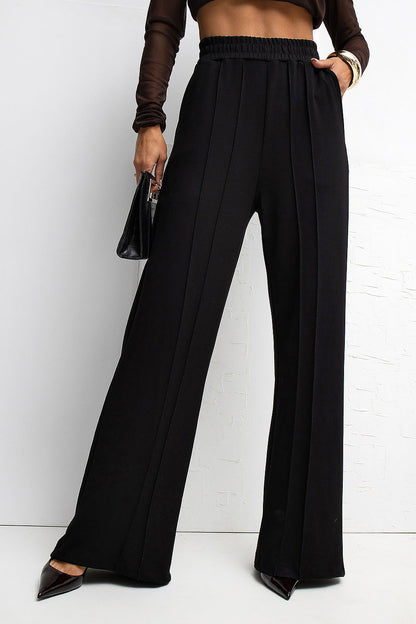 Model wearing Rue Paris Women's High Waist Wide Leg Tracksuit Trousers, demonstrating relaxed fit and modern styling ideal for chic yet casual outings.