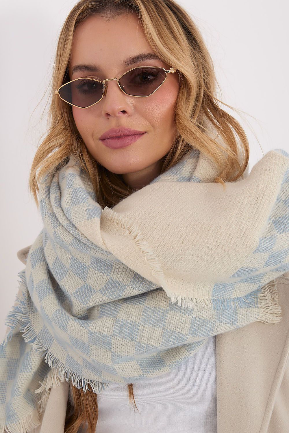 Stylish draping of AT's geometric shawl in soft hues, illustrating its modern character and upscale design.