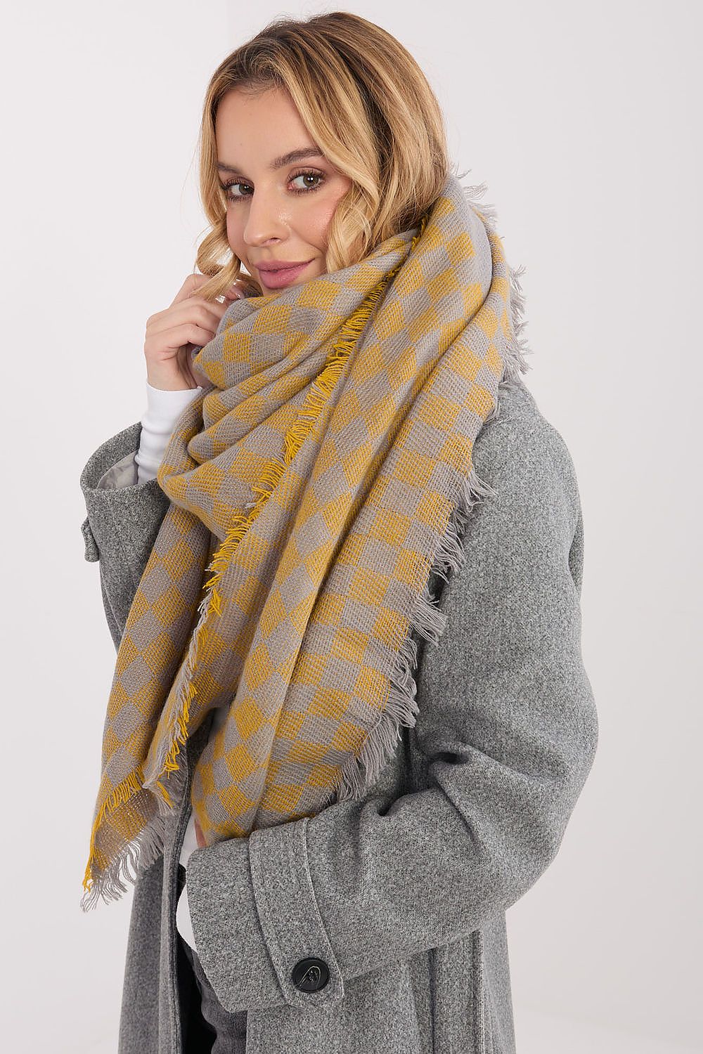 Stylish display of the fringed viscose-wool geometric shawl by AT, perfect for versatile styling.