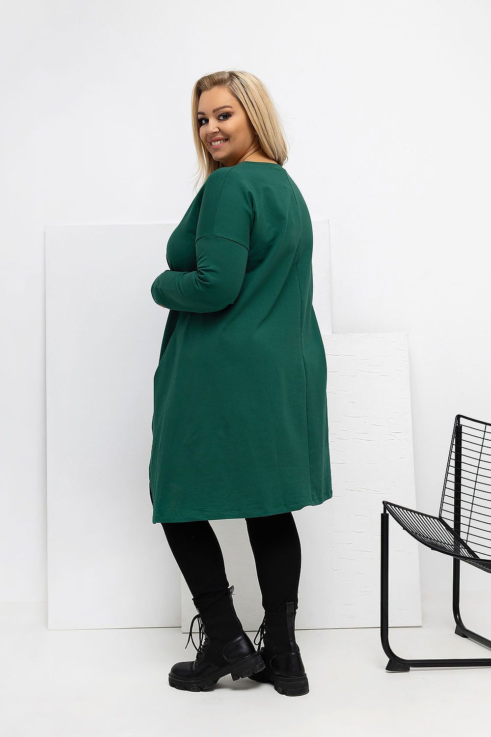 Model wearing the Relevance Plus Size Asymmetrical Tunic Dress with pockets, highlighting its fashionable long sleeves and trendy patch detail for a chic casual look.