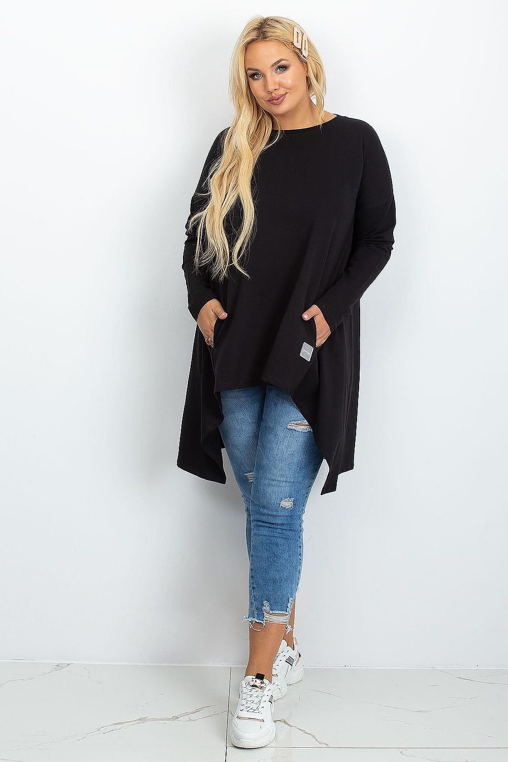 Model wearing the Luxury Plus Size Asymmetrical Tunic Dress from Relevance, styled with leggings for a chic look.