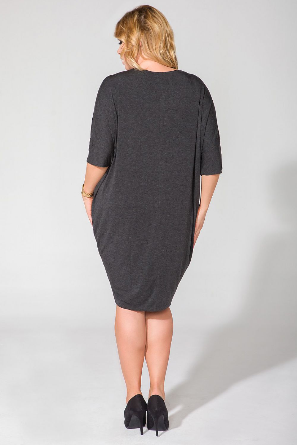 Model wearing Tessita Wide Cut Knit Dress with V-Shaped Neckline and Drape Finish - Luxurious Style, demonstrating its flattering fit and fashionable look.