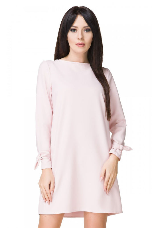 Elegant Mini Dress Tessita with Boat Neckline, Long Sleeves & Decorative Tie showcased in a luxurious setting, perfect for any occasion.