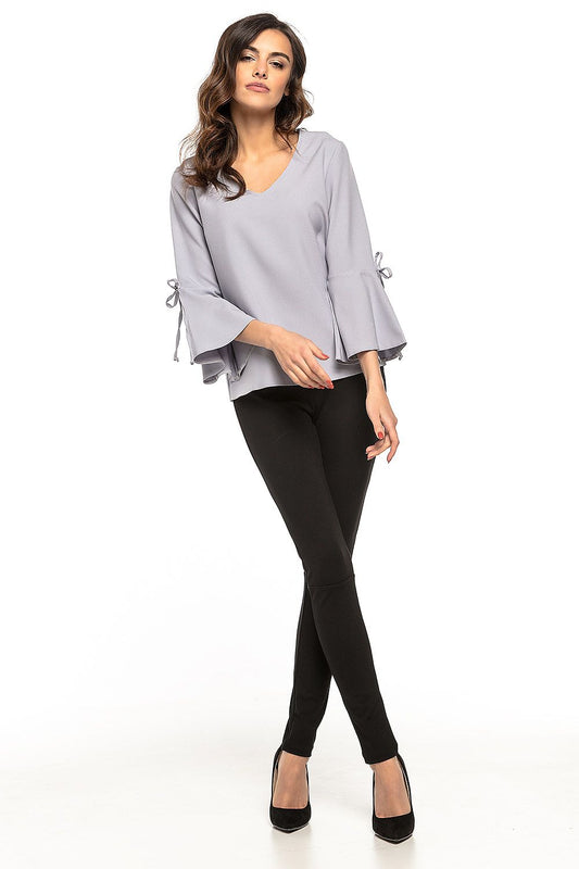 Elegant loose blouse with flirtatious frills and subtle V neckline by Tessita, showcasing sophisticated style and comfort, perfect for a chic evening outfit.