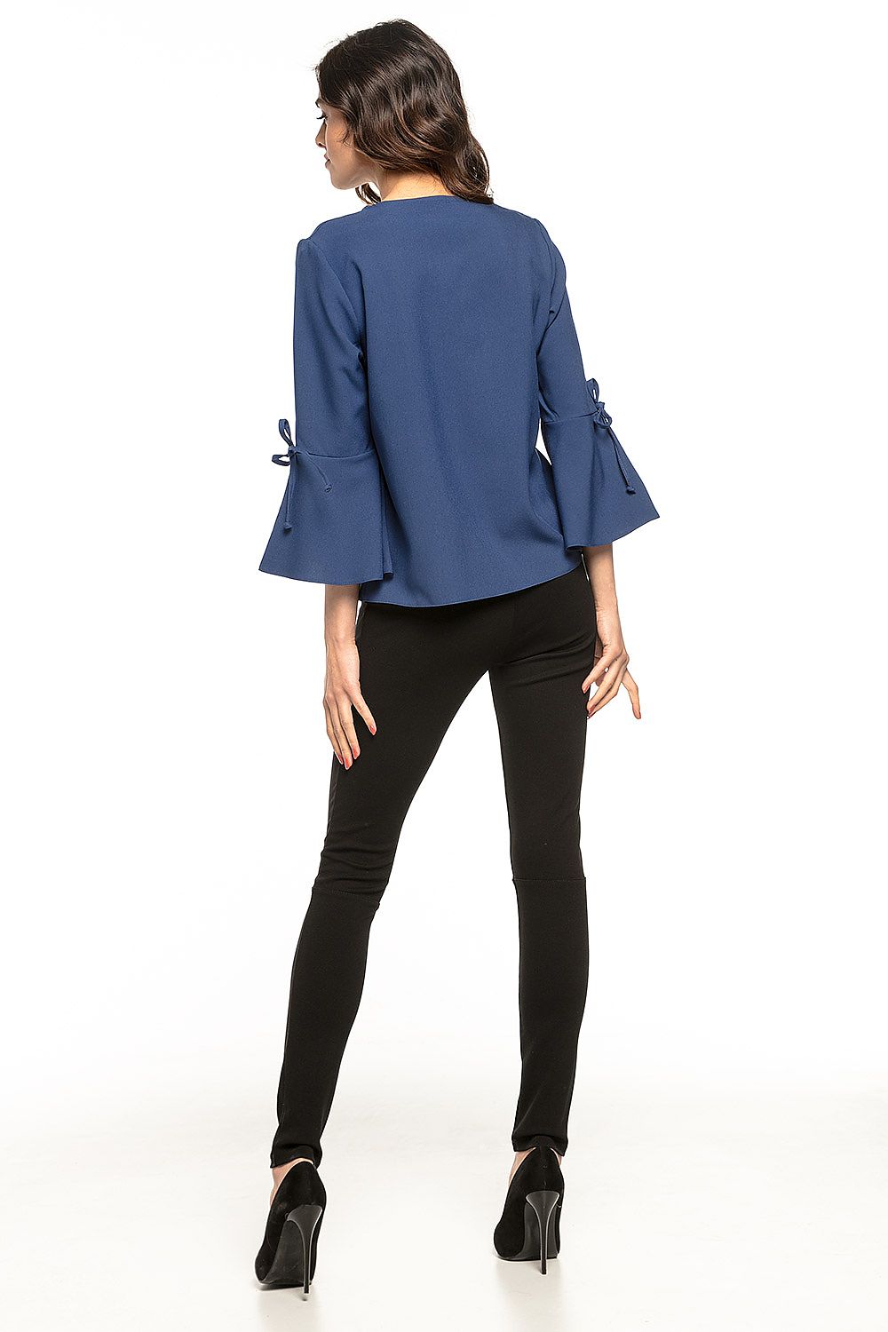 Model wearing Tessita's elegant loose blouse with frills, paired beautifully with casual trousers for a refined outfit.