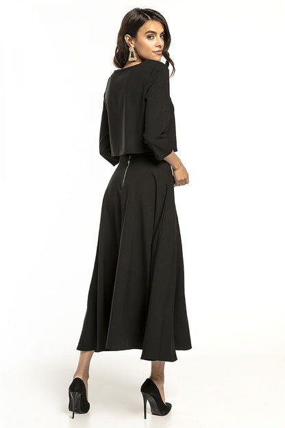 Stylish back view of a Tessita 3/4 sleeve blouse in classic black, paired with a flowing skirt, exuding elegance and refinement.