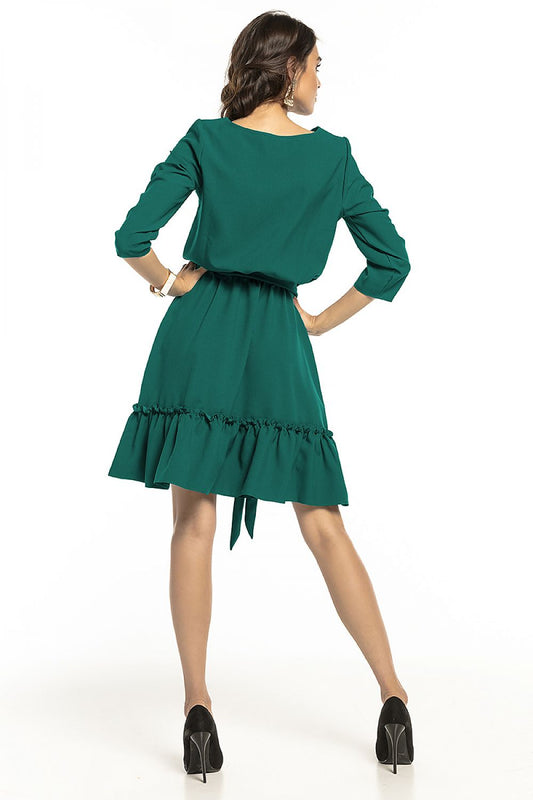 Back view of a fashionable model in the Tessita 3/4 sleeve daydress, highlighting the sophisticated flared skirt with frill and the elegantly tied belt, ideal for chic outings.