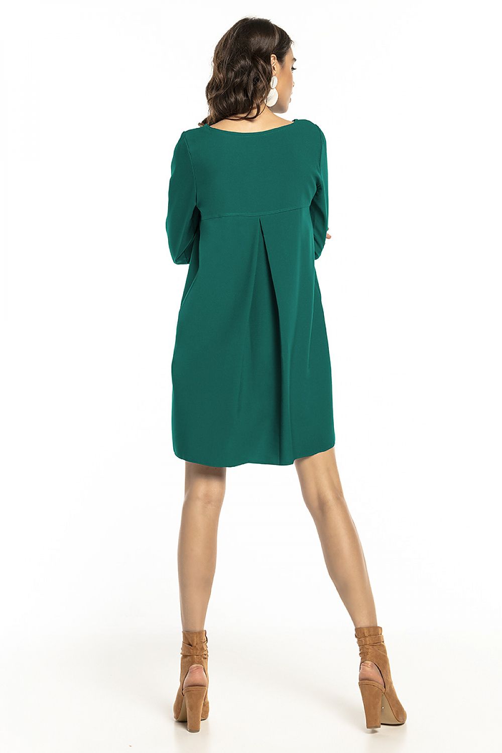 Elegant loose-fit dress from Tessita in deep green, featuring contrasting pleats at the back and 3/4 sleeves, styled with high-heeled ankle boots.